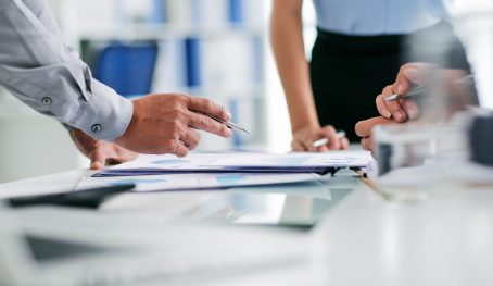 Hands of business people working with regulatory affairs documents